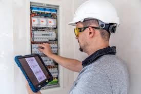 Elektriker arbeitet an Zaehlerschrank und prueft
